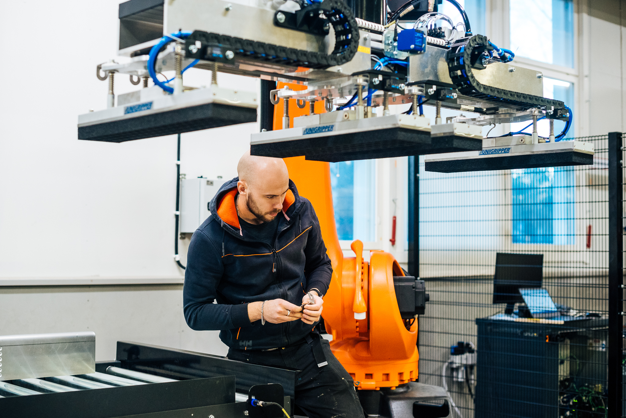 Engineer working on an industrial robotic system with an automated gripper.